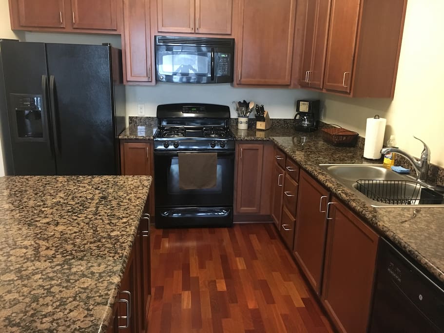 Kitchen with full refrigerator/ freezer, gas stove, coffee maker, microwave and full sized dishwasher.