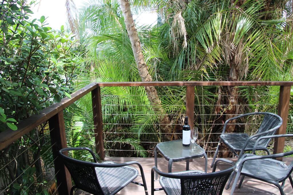 Private leafy outdoor deck with water views.
