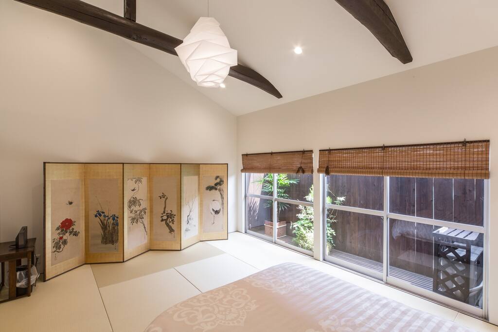 a bedroom with one double bed and a historical folding screen