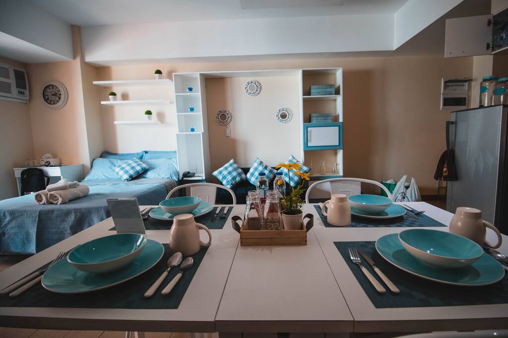 Wide screen shot capturing Bed, Sofa and diining area