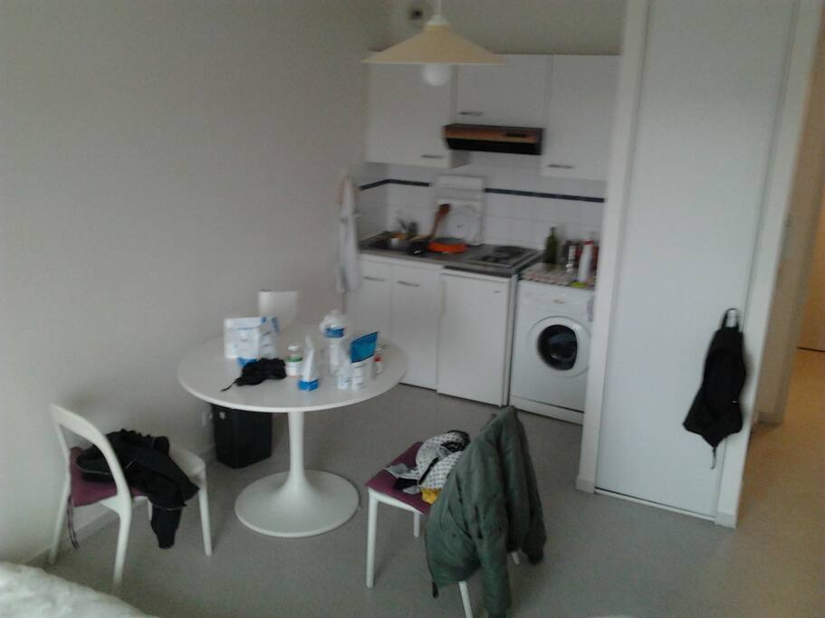 Table ronde + Chaises + Cuisine + Machine à laver + Placards + Cuisine