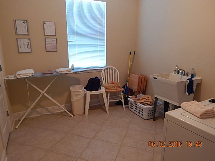 Spacious Laundry Room with wash basin and full size washer/dryer.