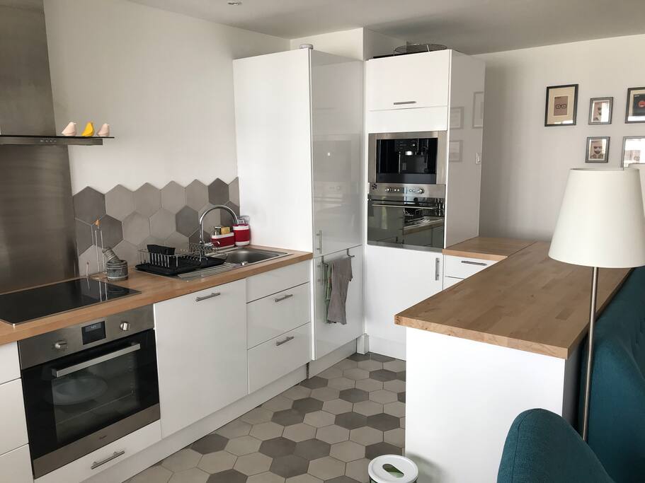 Cuisine équipée et ouverte sur le salon avec table ronde pour 4 personnes