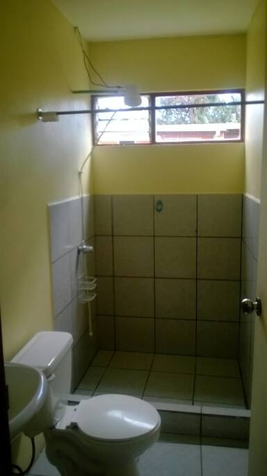 El servicio sanitario amplio y ducha con agua caliente.