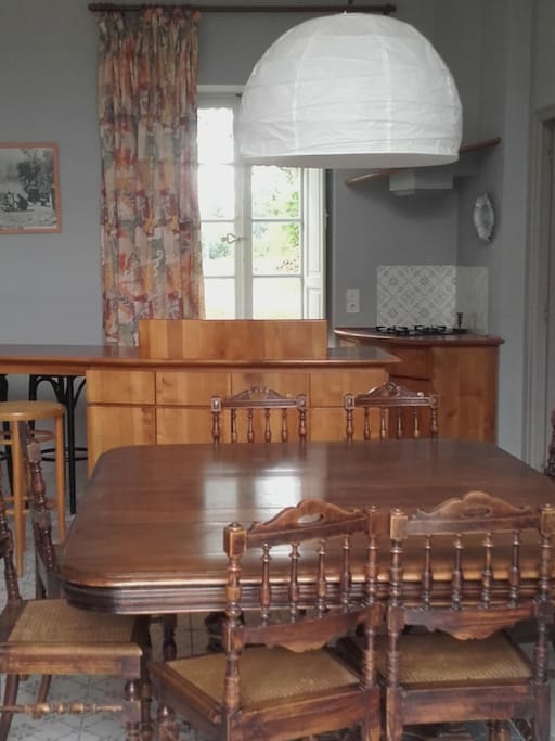 une table spacieuse très proche de la cuisine autant que de l'extérieur, pour des repas simples et faciles