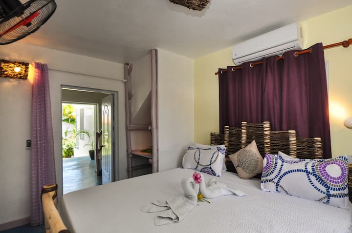 ห้องนอนชั้นล่างเตียงคิงไซส์โต๊ะทำงานขนาดเล็กและห้องอาบน้ำ