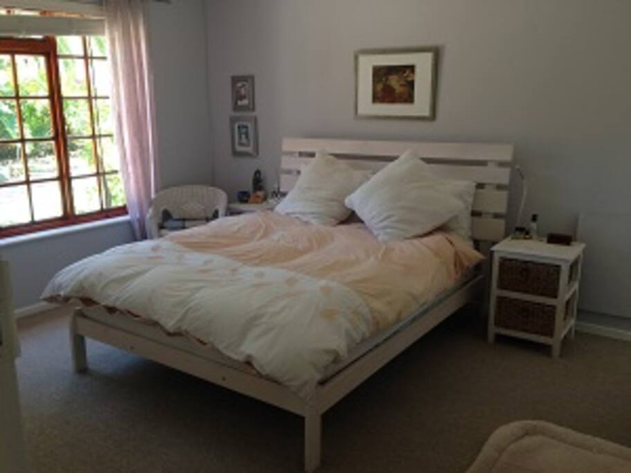 Main en-suite bedroom with built in cupboards and view onto patio