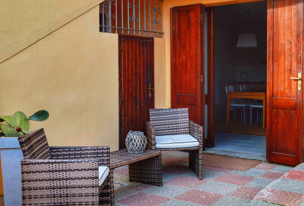 zona relax con poltroncine e tavolino in vimini all'aperto