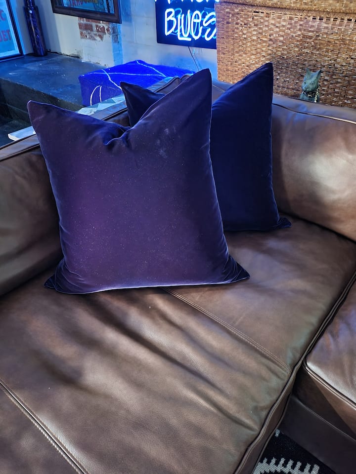Enjoy luxurious blue velvet covered goose down pillows on a deep chocolate leater sectional sofa, perfect to sink into.