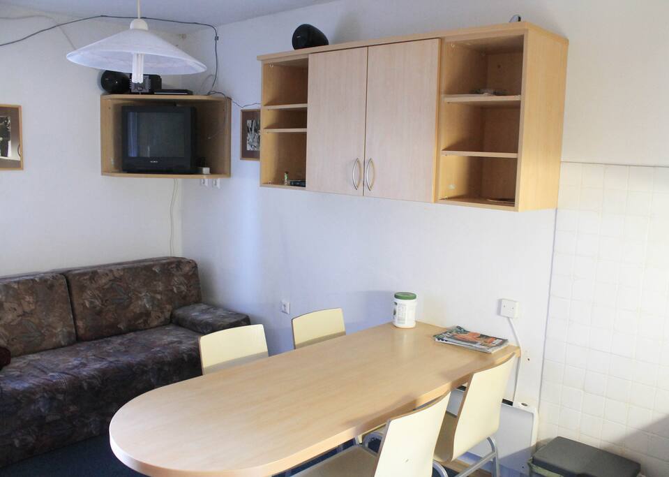 Living room with dining table, sofa bed and TV