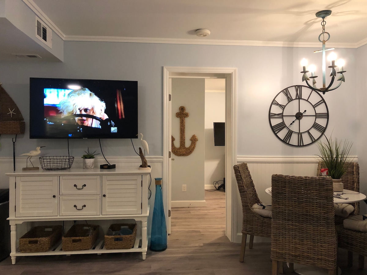 Obývacia izba a jedáleň s veľkou 50-palcovou inteligentnou televíziou s plochou obrazovkou.