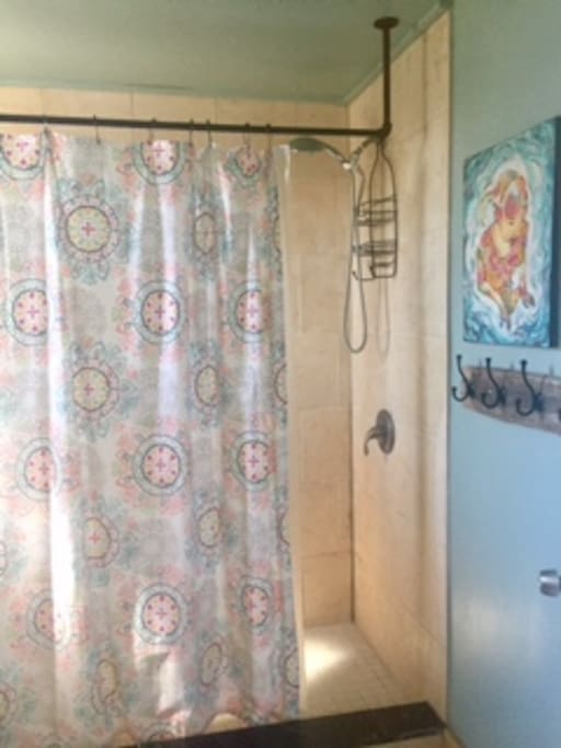The one bathroom is in the back of the house is sunny and features this spacious shower.
