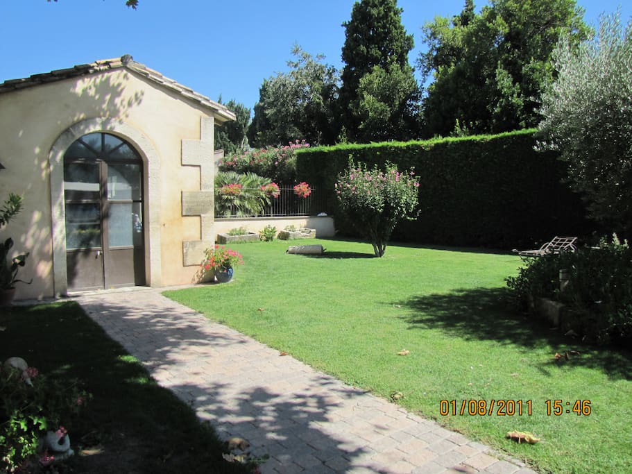 Jardin avec pelouse et en fond muret avec grille à l ancienne donnant à la piscine!