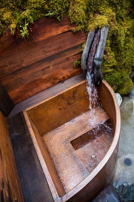 A waterfall fills this luxurious hand hammered copper soaking tub.