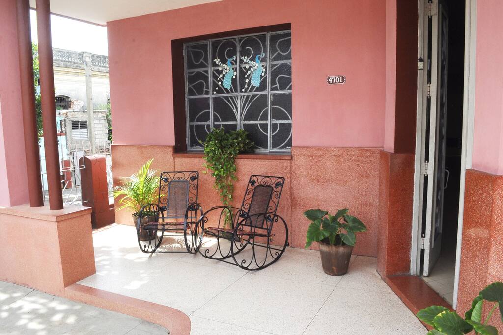 Wide hallway with the typical and comfortable Cuban armchairs. Easy access from the street/ Amplio portal con los típicos y cómodos sillones cubanos. Fácil acceso desde la calle