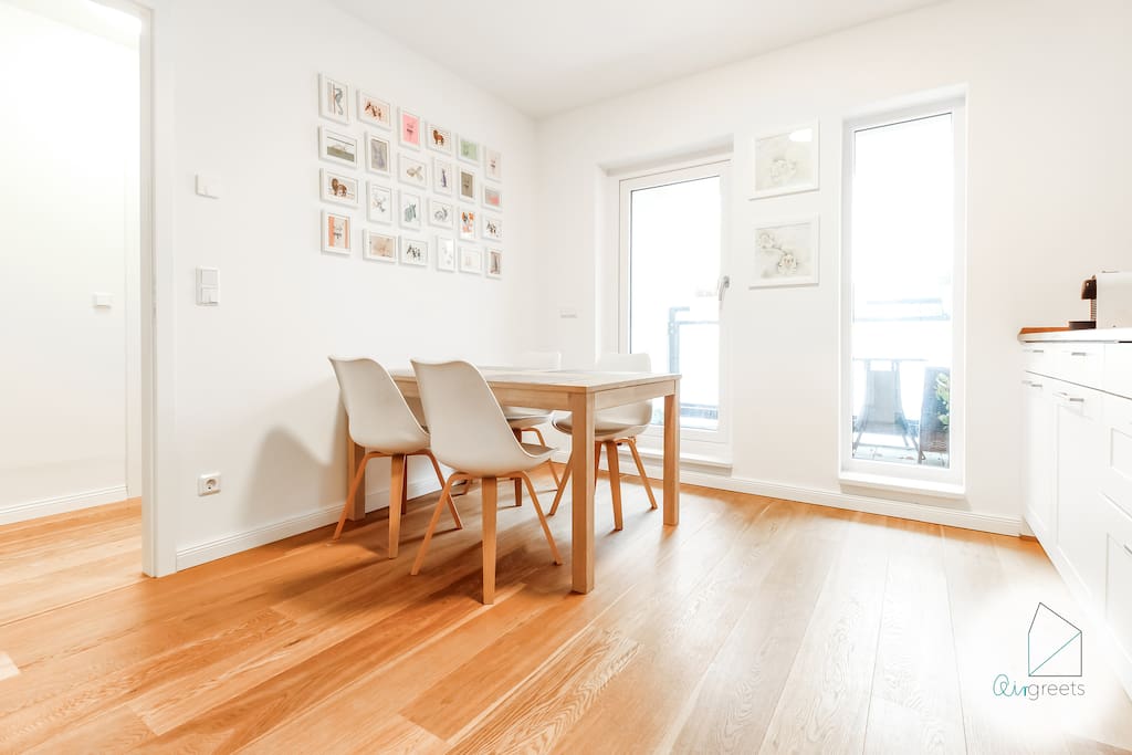 The spacious kitchen with its big windows is bright and has a nice wooden floor.