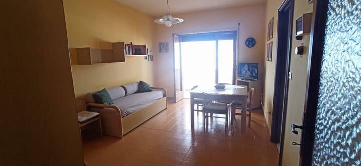 Séjour avec canapé-lit,télévision 32 pouces smart,fauteuil Ikea et table pour au moins six personnes ouvrant.