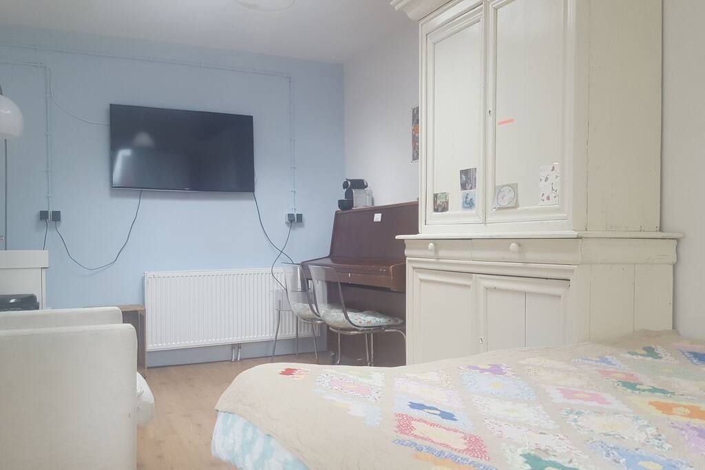 Room with television with NetFlix, relax chairs and piano