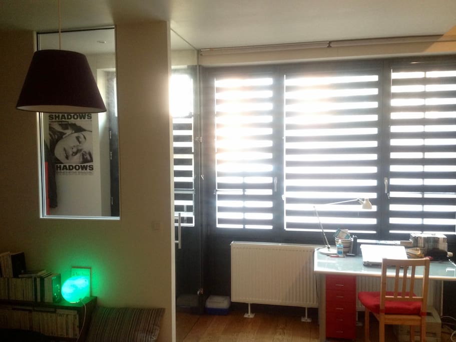 Salon avec coin bureau et fenêtres / Living room with a desk corner in front of the windows