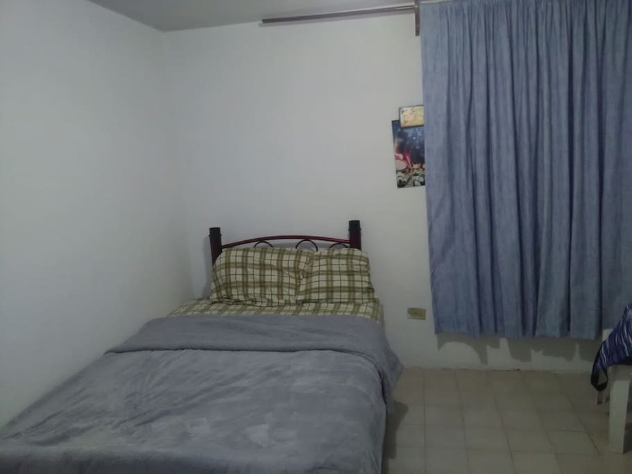 Este es el cuarto grande, tiene un colchón matrimonial, hay cosas propias en el cuarto pero tiene suficiente espacio. Este cuarto no tiene chapa de momento pero si puede cerrarse, tiene un huequito en la puerta pero se tapa bien