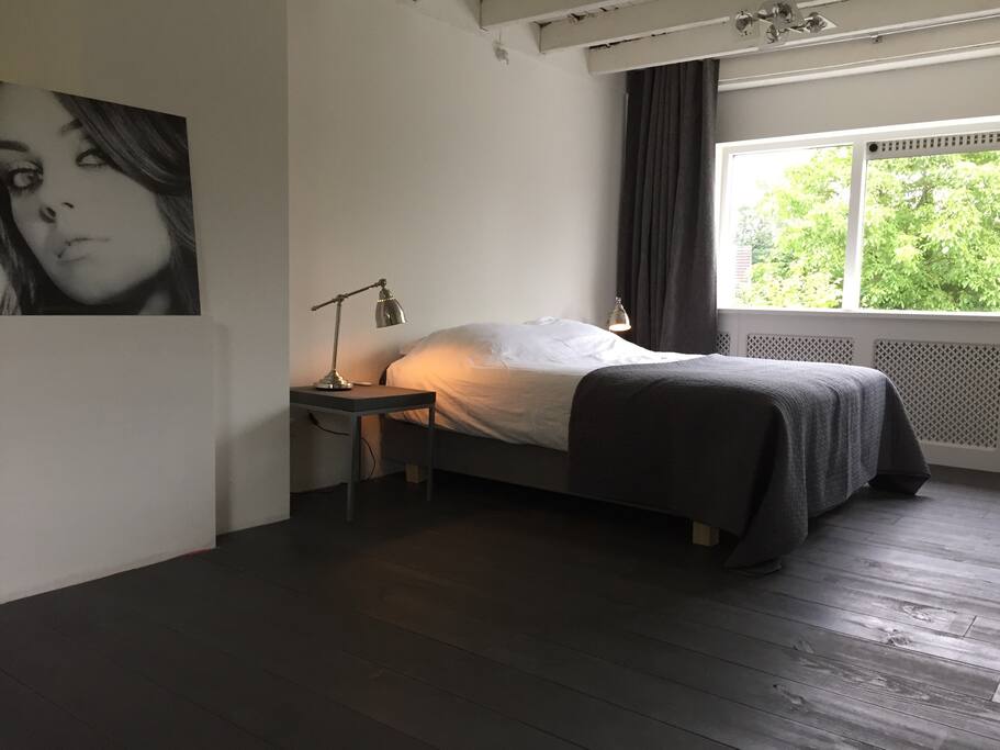 Spacious bedroom with high ceilings.