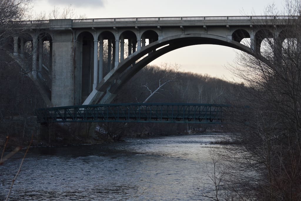 Charming pedestrian footbridge below historic Blackstone River bridge built earlier 20th century