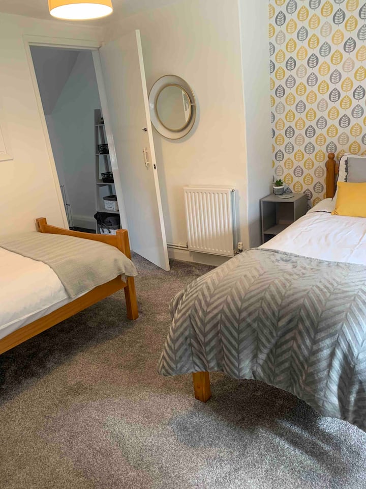 ห้องนอนที่สองมีเตียงเดี่ยวสองเตียงที่นำไปสู่ห้องน้ำสำหรับครอบครัวที่ได้รับการตกแต่งใหม่