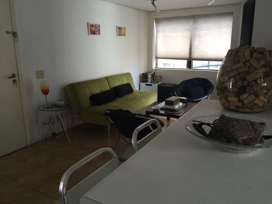 First floor, living room. Entrance door. View from kitchen. Sofa is a sofa bed.