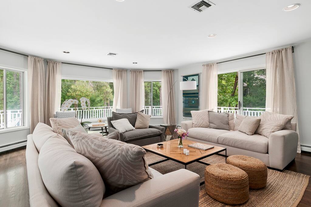 The living room has ample seating and is surrounded by the front porch