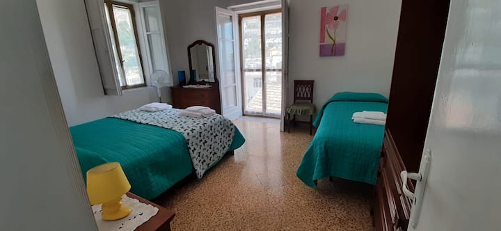 Dormitorio 1 con cama tamaño queen y cama individual, con ventana y balcón