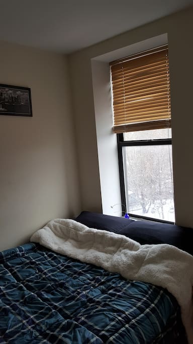 Full size mattress fitting two is on risers, providing storage space underneath the bed.