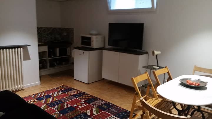 غرفة بمساحة 18 مترًا مربعًا مع  مطبخ صغير وغرفة طعام وبيز. 
