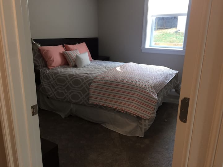 Bright light in bedroom, facing private side yard.  There are blinds on the window,, a spacious walk-in closet, side tables with drawers, and a nice bench for shoes and other items you want to have close by.  Door from bedroom to bath.