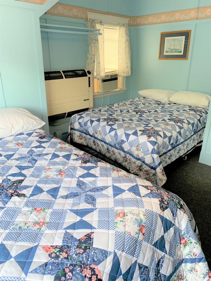 chumba cha kulala na vitanda 2 vya ukubwa kamili vinavyoelekea nyuma ya nyumba.