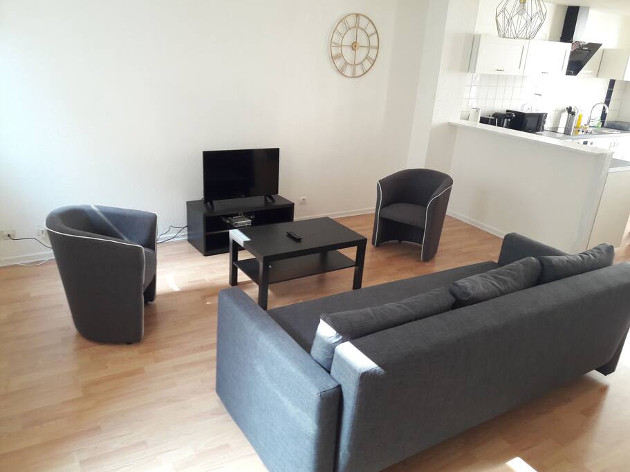 Le salon avec un grand canapé 3/4 places et deux fauteuils