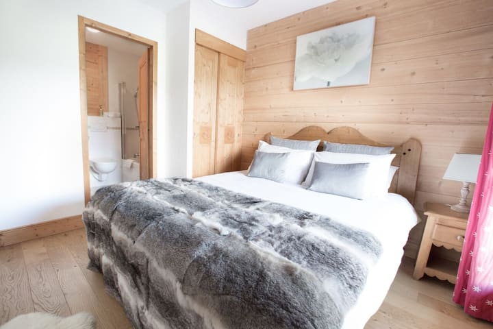 חדר שינה ראשי במיטת קינג סייז/זוגית בקומת הקרקע עם חדר רחצה צמוד