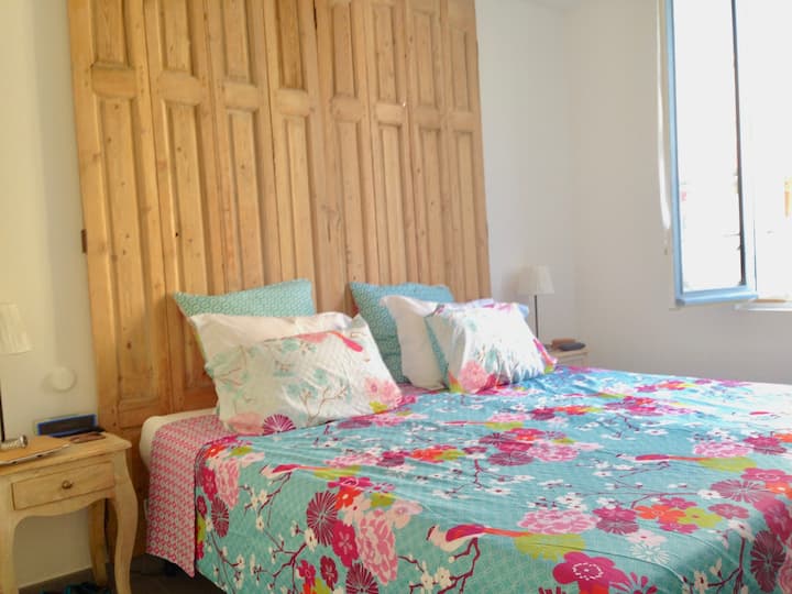 The Master Bedroom, with it's repurposed wooden shutter headboard.
