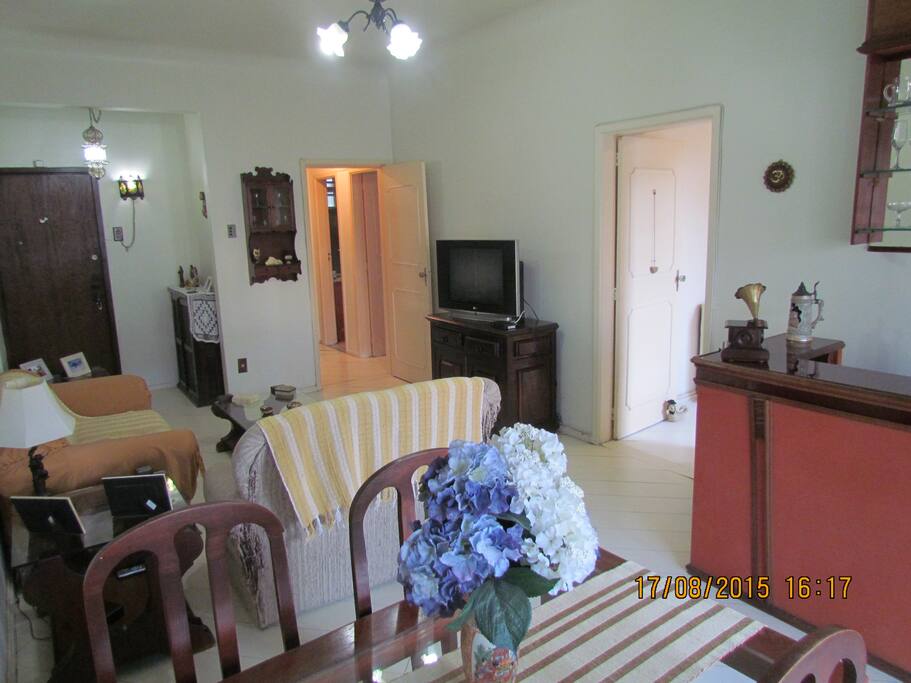 TV, ventilador de teto, mesa de jantar, e sofá.