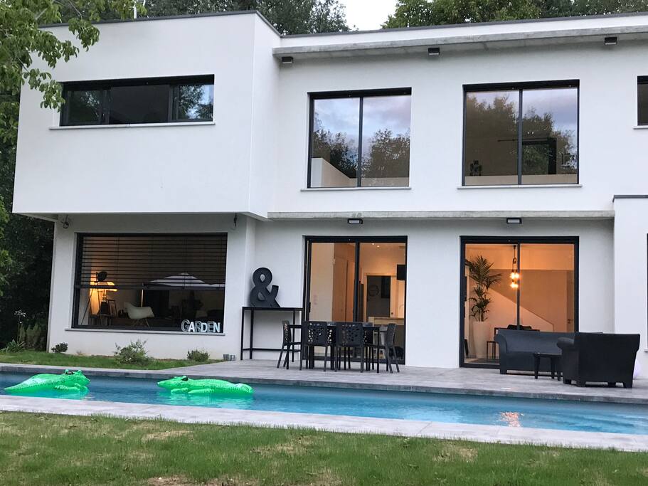 Maison côté terrasse et piscine avec 2 grandes baies vitrées pour profiter de l'intérieur avec la cuisine et de l'extérieur