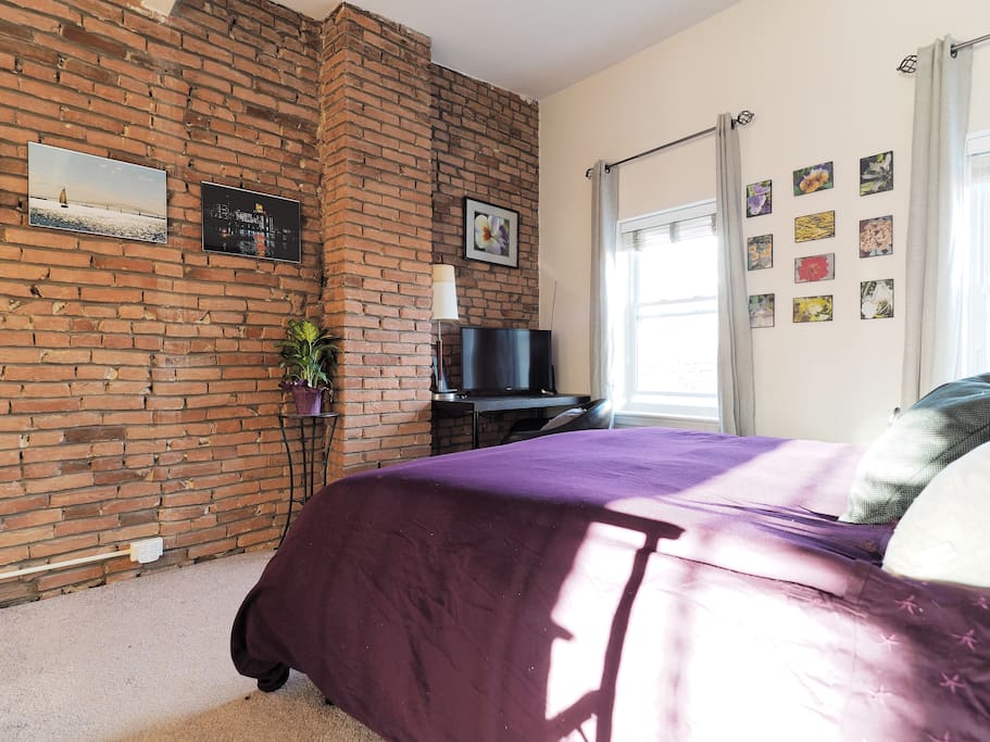 Master bedroom has gorgeous exposed turn-of-the-century brick- with all the modern comforts!