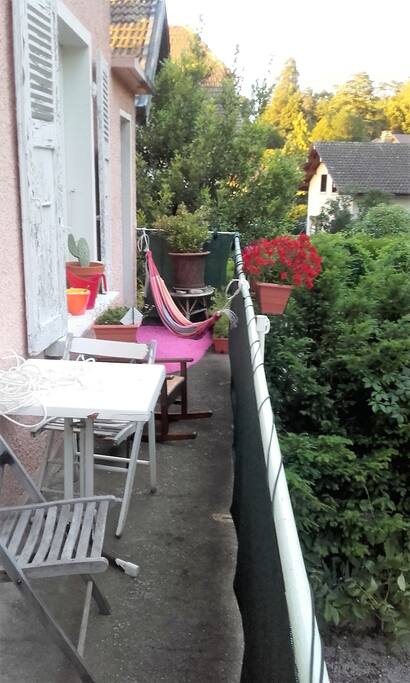 Balcon arrière ensoleillé jusqu'à 16h avec hamac, table et chaises.
