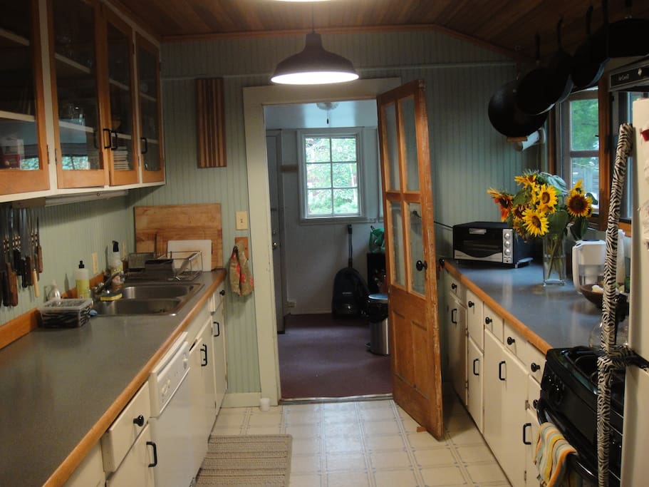 The galley-style kitchen is now maroon-and-white.