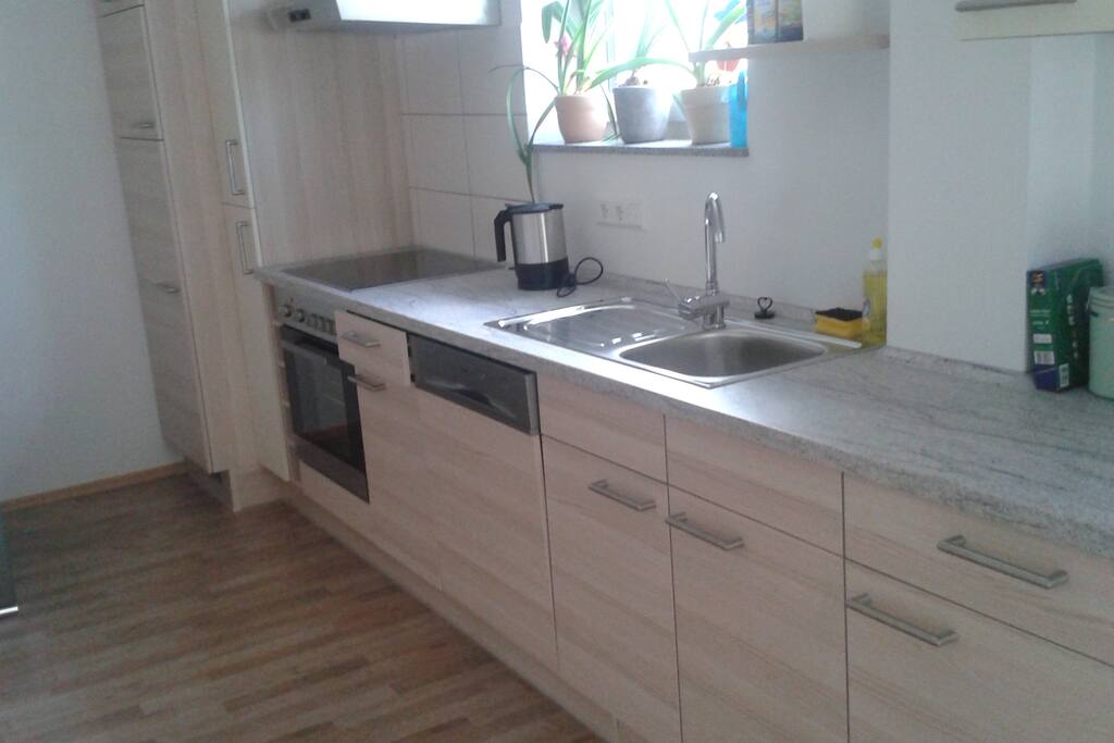die modern ausgestattete Küchenzeile mit Geschirrspüler, Gefrierfach, Backofen, Wasserkocher