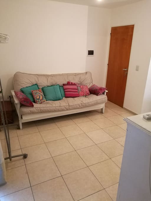 Futon, con disposición a TV, convertible en cama.