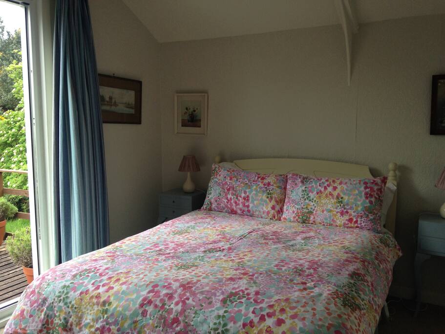 The bedroom has patio doors which open out onto a sunny deck.