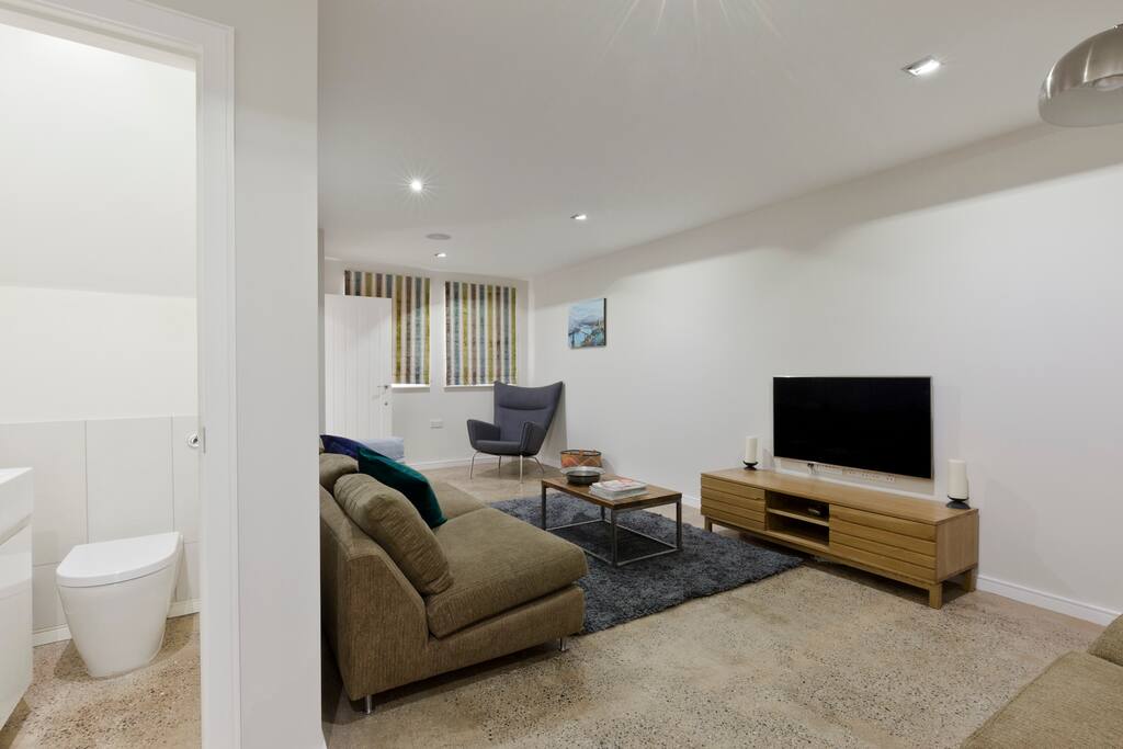 The lounge features a Samsung LED TV and comfy sofas. There is also a toilet downstairs