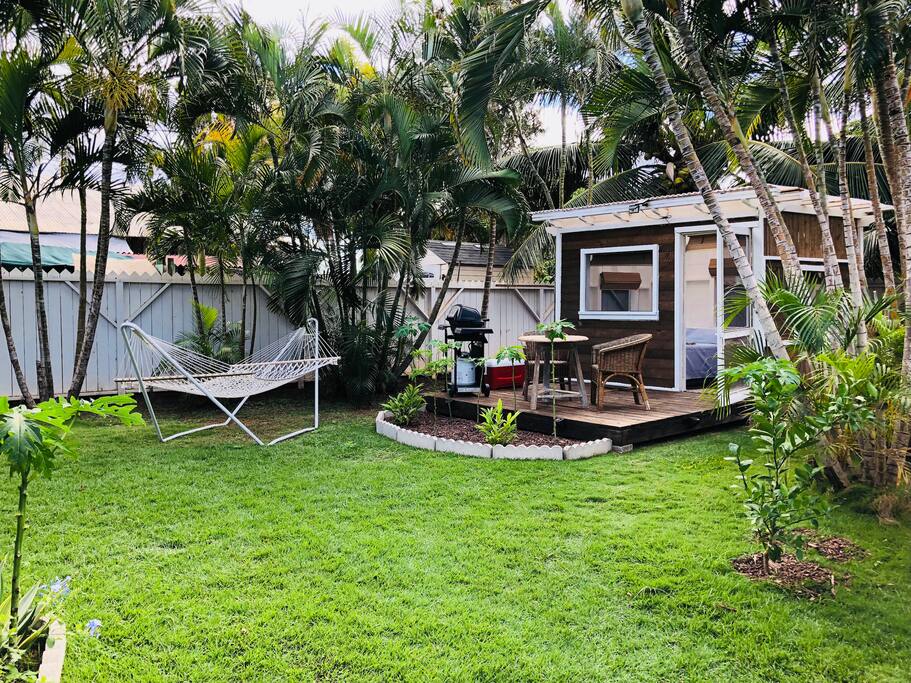 Full view of Jungalow with lush grass and hammock for lounging.