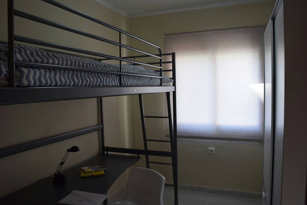 Habitación (1) con cama tipo litera, escritorio y armario.