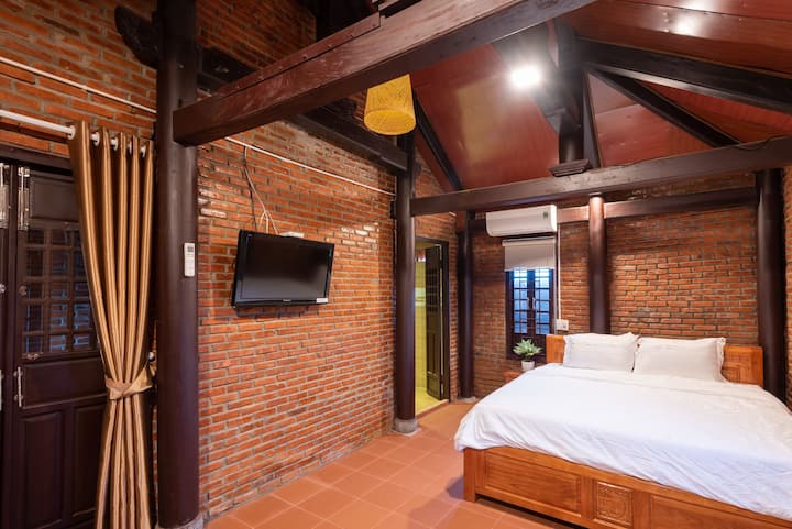 Room with 2 color tones: orange and brown, was designed in Vietnamese traditional style- brick and wood and use all-wooden interiors