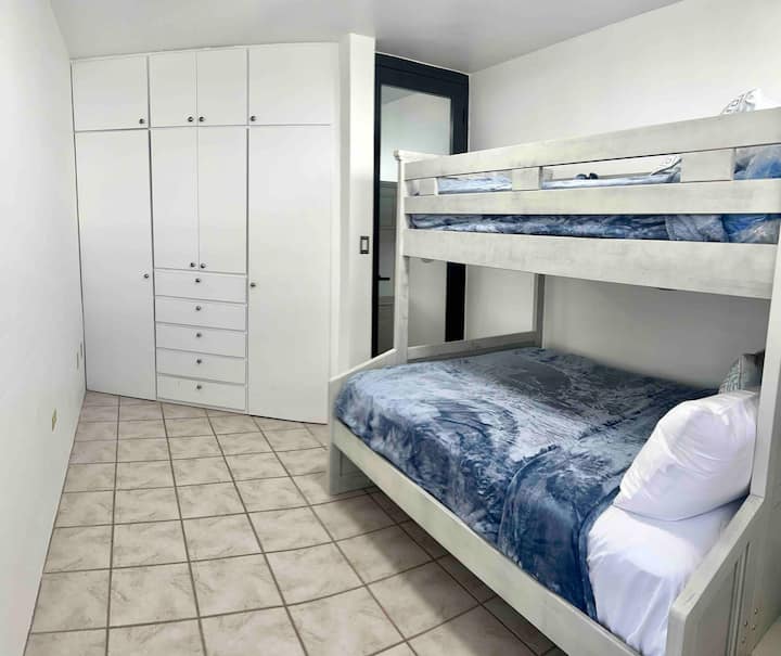 Uitzicht op de eerste slaapkamer met een stapelbed, kleine tweepersoonskamer aan de bovenkant en full size aan de onderkant. 